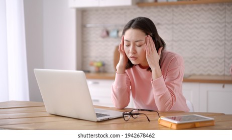Stressed overworked mixed race business woman working from home take off glasses feel eye strain fatigued from laptop computer. Tired asian freelancer suffer from headache pain, remote work concept - Shutterstock ID 1942678462