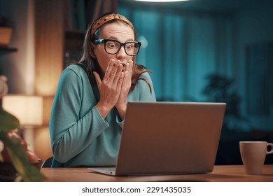 Stressed panicked woman working with her laptop at home, she is having computer problems: system failure and virus infection concept