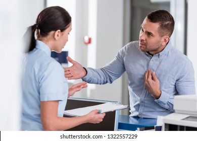 Stressed Patient Talking To Nurse In Clinic