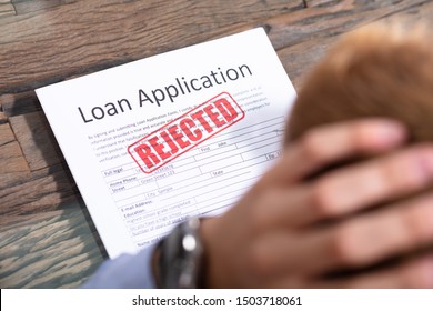 Stressed Person Looking At Rejected Loan Application