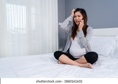 Stressed Pregnant Woman Talking On A Mobile Phone In A Bed