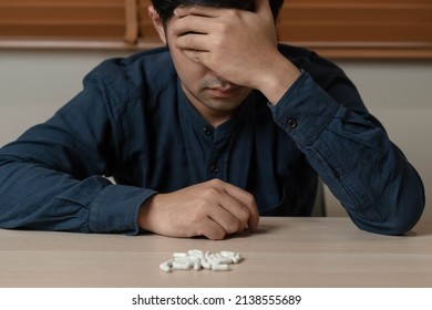 Stressed, sad asian young man, male abuse overdose pills and addict, take medicine. Sick pain of health treatment, unhappy people. Suicide depressed or despair.