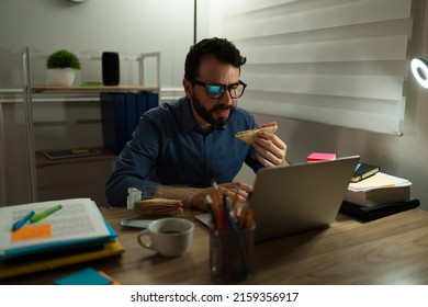 Stressed Sad Man Staying Very Late At The Office And Eating Dinner While Finishing A Work Deadline 