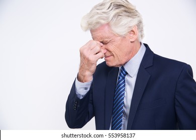 Stressed senior Caucasian businessman rubbing eyes