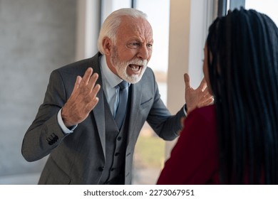 Stressed senior financial manager losing his temper after being irritated with underperformance of company employee, frantically shouting yelling at female coworker while standing in office.