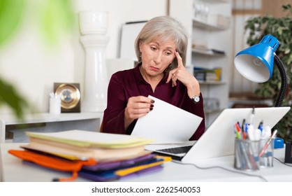 Stressed senior woman working in office, overwhelmed with computer work - Powered by Shutterstock