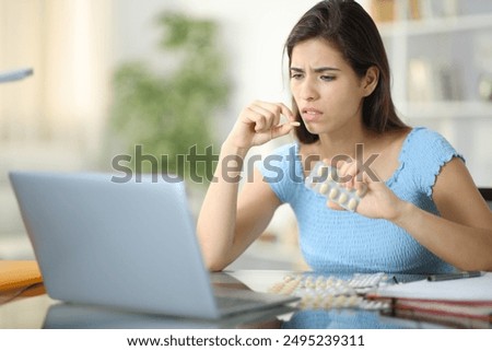 Stressed student e-learning taking pills at home
