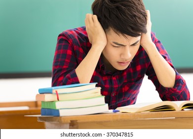 Stressed Student  Studying For Exam In Classroom