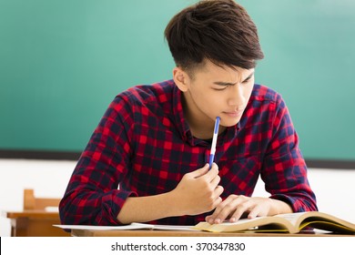 Stressed Student  Studying For Exam In Classroom