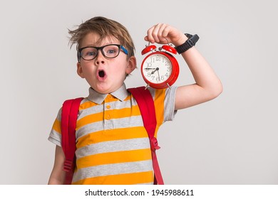 Stressed Surprised And Angry Kid Yawn And Holding Alarm Clock. Change Time. Pupil With Bag And In Glasses. Hurry Up. Time To Go To School.