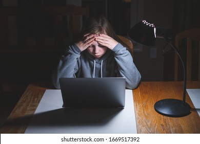 Stressed Teen Girl Working/studying With A Laptop At Night On A Desk.