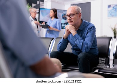 Stressed tired senior patient sitting on chair in hospital lobby while waiting for specialist doctor to start medical examination during checkup visit consultation. Health care service and concept - Powered by Shutterstock