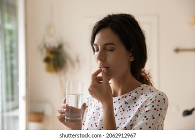 Stressed tired woman taking vitamins, painkillers, antidepressants, pills, meds against headache, insomnia, nervous disorder, anxiety. Patient with medication fighting against flu infection, migraine - Shutterstock ID 2062912967