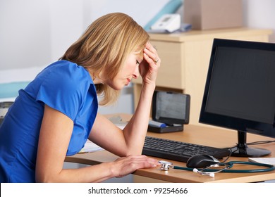 Stressed UK doctor sitting at desk