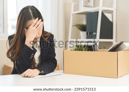 Stressed of unemployment, quitting job concept, desperate asian young business woman resigning or fired, leave from company, take belongings, stuff into box cardboard, layoff or leaving, changing work