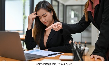 A Stressed And Upset Asian Businesswoman Or A Female Office Employee Gets A Bad Complaint And An Opinion From Her Boss.