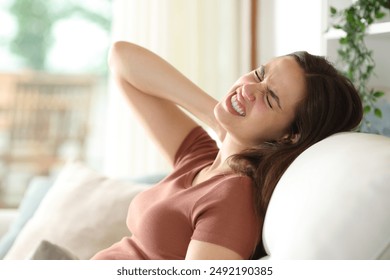 Stressed woman complaining suffering neck ache on an uncomfortable couch at home - Powered by Shutterstock