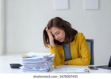 Stressed woman at desk with a stack of papers, exhausted at work. Concept of overworking, pressure, and fatigue in office environment.
