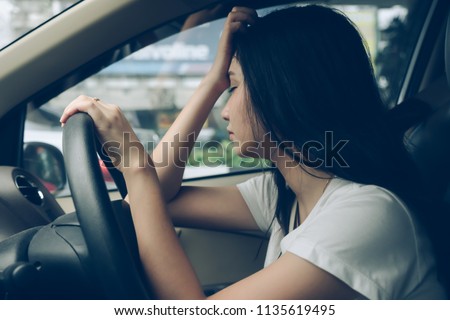 Stressed woman drive car feeling sad and angry.
Asian girl tired, fatigue on car. Driver tired drowsy, drink don’t drive concept.
Sleepy and drunk female hangover. Illegal law driver license.
