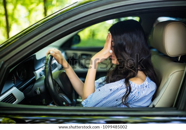 Stressed\
woman driver with hands on head in her\
car.