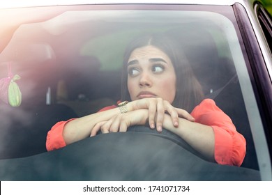Stressed woman driver sitting inside her car. Sad female driver driving a car. young woman stuck in a traffic jam. Woman annoyed in car. Girl stuck in traffic.
