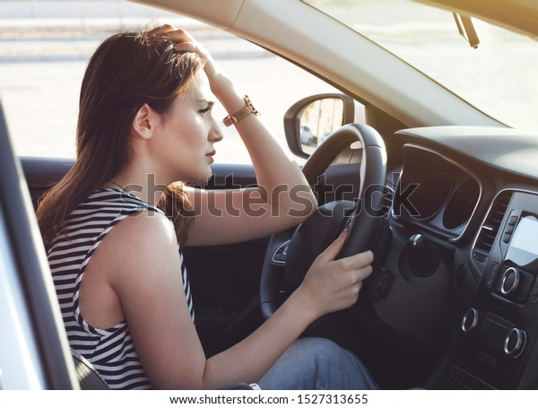 Stressed woman driver\
sitting inside her car