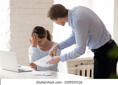 Stressed Woman Gets Scolding From Boss. People At Work. Conflict Between Employer, Employee. Angry Boss Criticizes Report Of Colleague. Manager Gives Dismissal Notice To Worker. Upset Woman Gets Fired