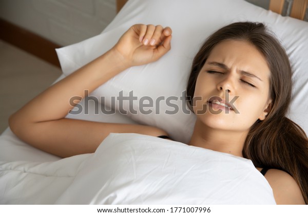 stressed woman with grinding teeth, bruxism\
symptoms; portrait of stressful, exhausted, tired sleeping woman\
grinding teeth with stress; oral, dental care medical concept;\
caucasian adult woman\
model
