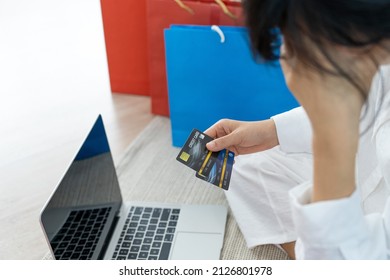 Stressed Woman Holding A Credit Card After Shopping. No Money To Pay Off Credit Card Debt.