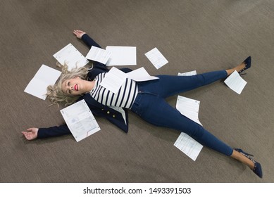 Stressed Woman Lying I Office With Papers Stressed In Cliche Image