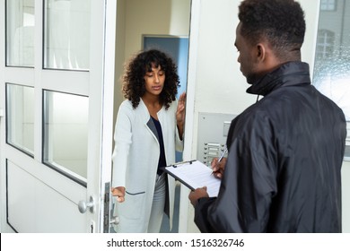 Stressed Woman Opening Door To Bailiff At Home