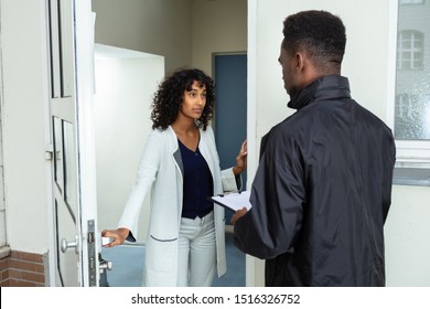 Stressed Woman Opening Door To Bailiff At Home