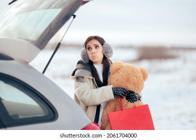 Stressed Woman Putting Christmas Gifts In The Car Trunk. Tired Mom Carrying Last Minute Bought Presents To The Automobile
