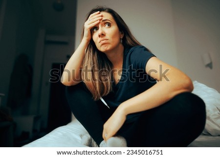 
Stressed Woman Sitting in Bed Feeling a little Confused. Distraught girl feeling alone and unlucky 
