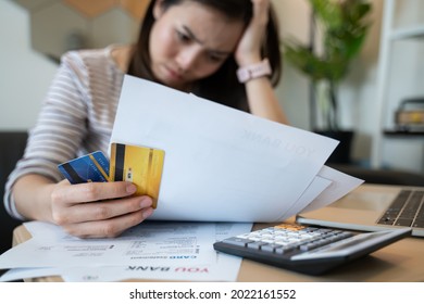 stressed woman trying money to pay credit card debt and many expenses bills such as electricity bill,water bill,internet bill,phone bill during covid-19 or coronavirus outbreak at home - Shutterstock ID 2022161552