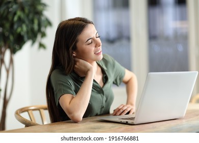 Stressed woman using laptop complaining having neck ache at home