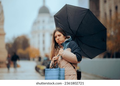 
Stressed Woman Walking in the Rain with Broken Umbrella 
Girl having an accident feeling unlucky in a rainy day

