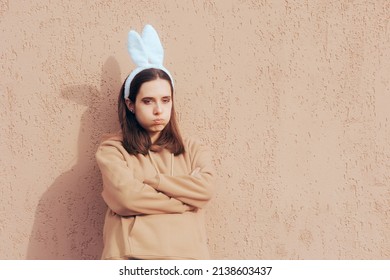 
Stressed Woman Wearing Costume Bunny Ears Feeling Upset. Unhappy girl standing with arms crossed wearing a rabbit headpiece party accessory
