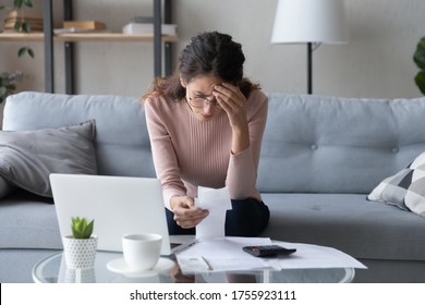 Stressed Woman Wearing Glasses Checking Bills, Feeling Anxiety About Debt Or Bankruptcy, Lack Of Money, Unhappy Female Sitting On Couch At Table With Laptop, Holding Receipt, Planning Budget