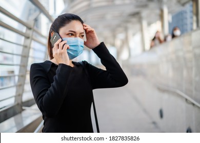 Stressed Woman Wearing Medical Mask And Talking With Mobile Phone About Her Business Problem, Protection From Coronavirus (covid-19) Pandemic