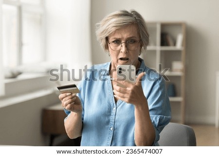 Stressed worried elderly pensioner woman having problems with credit card, online payment, financial security, looking at smartphone screen in shock, finding overspending