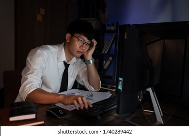 Stressed Young Asian Business Man Working Late Night Alone In Office Late His Eyes Are Gonna Closing At Table And Looking Headache Sleepy, Overtime Overload Working Concept.