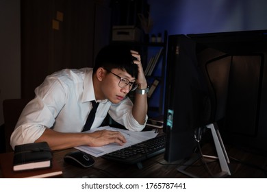 Stressed Young Asian Business Man Working Late Night Alone In Office Late His Eyes Are Gonna Closing At Table And Looking Headache Sleepy, Overtime Overload Working Concept.