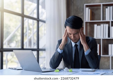 Stressed young asian businessman,Documents related to finance, tax ,push down calculator to calculate tax income and expenses, bills, office.Financial, finance concept - Shutterstock ID 2268732479