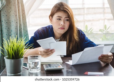 stressed young asian woman trying to find money to pay credit card debt.
