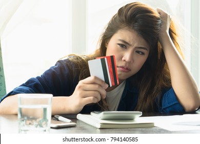 Stressed Young Asian Woman Trying To Find Money To Pay Credit Card Debt.