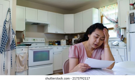 Stressed Young Asian Woman Unemployed Reading Paper Pay Bills , Feeling Frustrated Of Getting Eviction Letter Or Bank Debt Notification, Thinking Of Financial Problems. Concept Unemployed Pay Bills. 