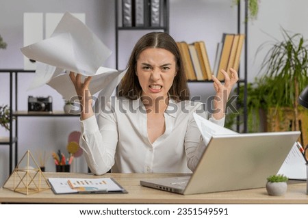Stressed young business woman working looking at unpaid bank debt bills, doing paperwork, planning budget, calculate finances mortgage payments at office. Displeased freelancer girl throws paper bills