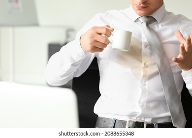 Stressed young businessman with coffee stains on his shirt in office - Shutterstock ID 2088655348
