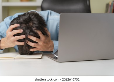 Stressed young businessman, trader or investor touch head, disappointed when bad investment or economic crisis, losing money from investing, trading stock, Cryptocurrency as Bitcoin on laptop at home.
